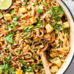 skillet with tofu pad thai and limes