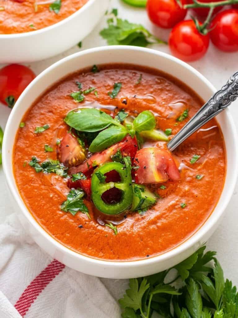 A white bowl with tomato gazpacho soup