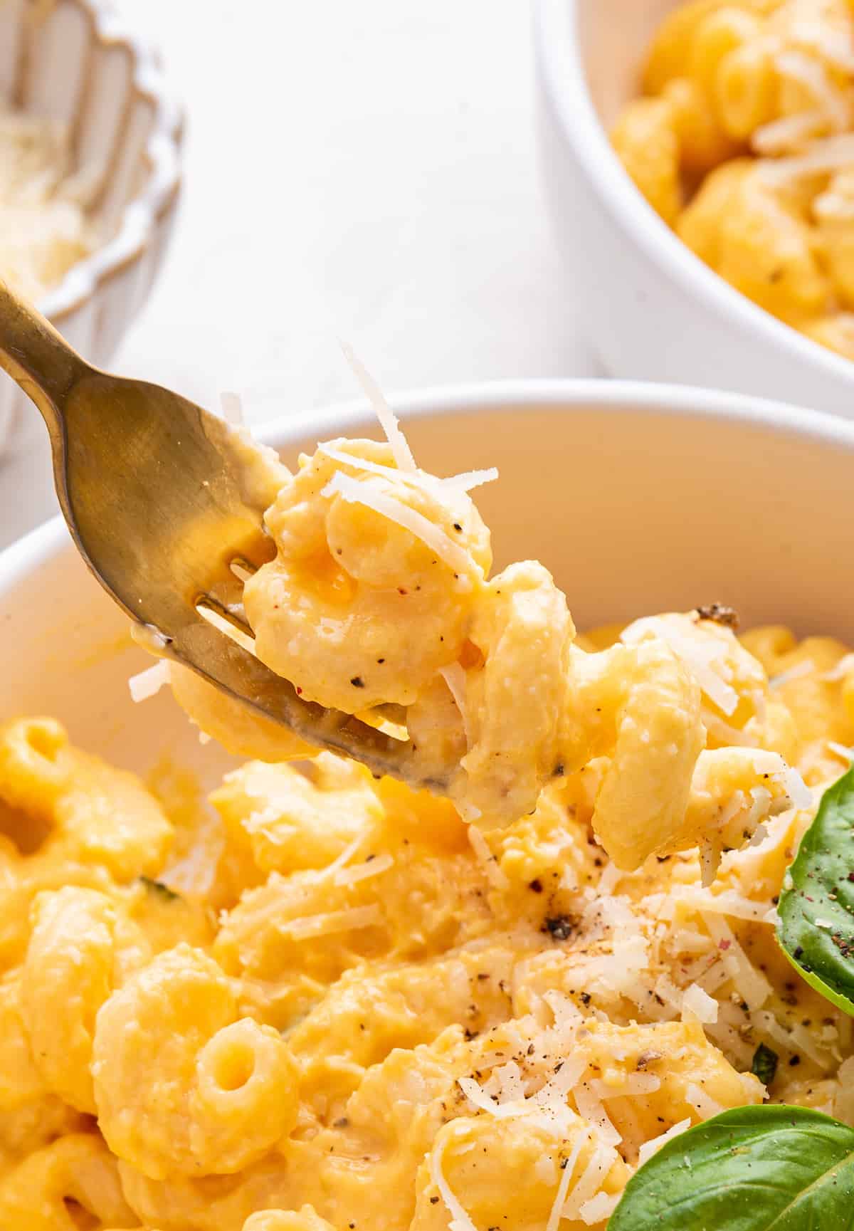 Fork lifting butternut squash mac and cheese from bowl