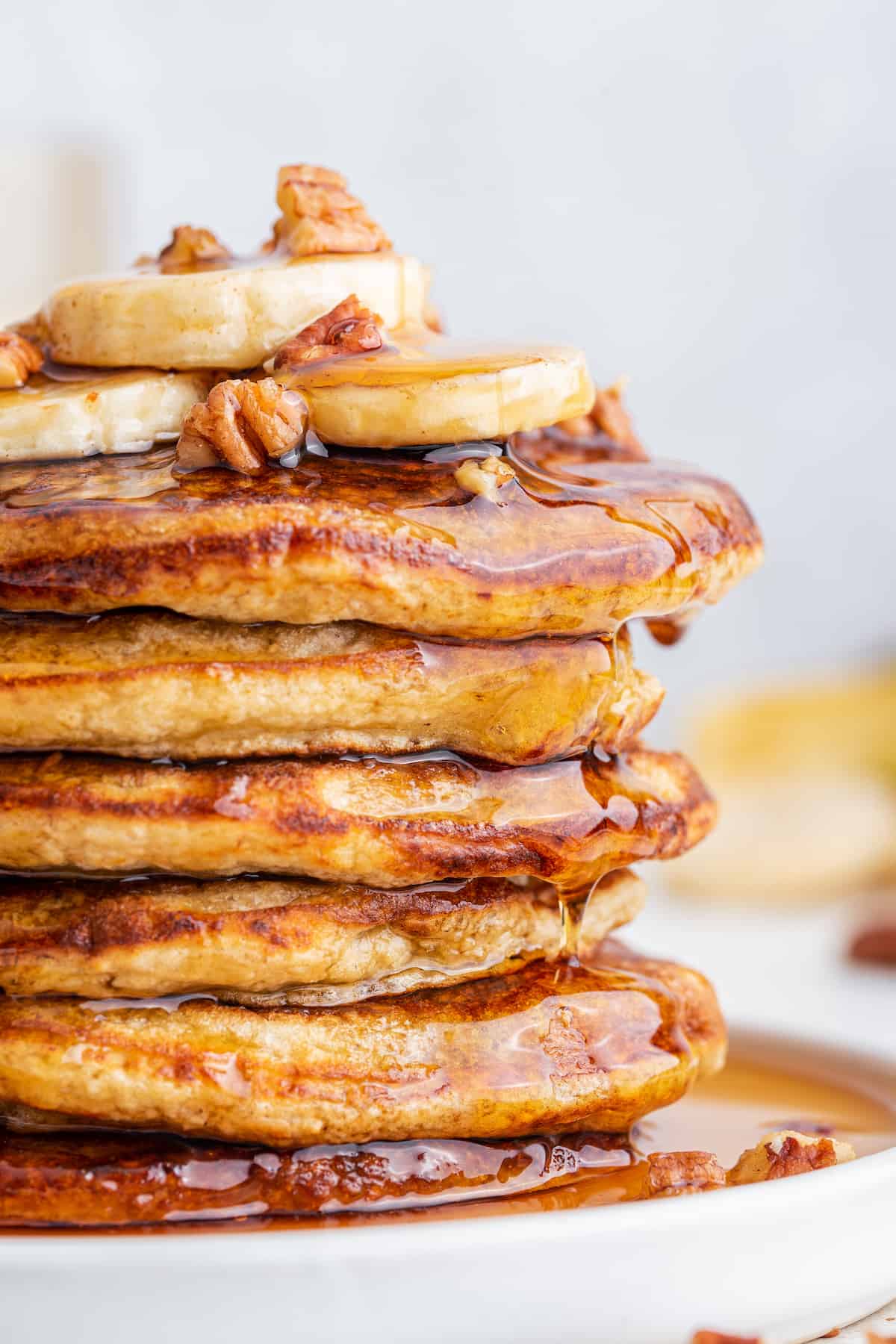 Side view of oatmeal banana pancakes stacked on plate to show thick, fluffy texture