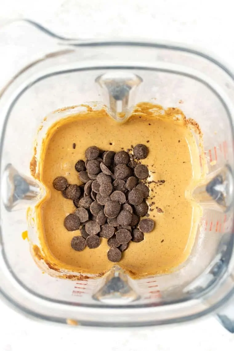 Overhead view of chocolate chips added to muffin batter in blender
