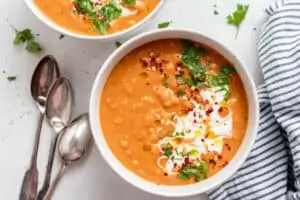bowl of red lentil soup with cream on top